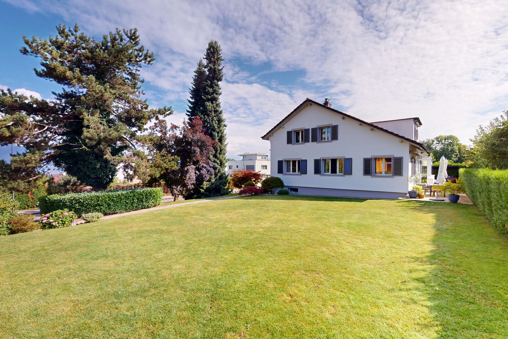 façade avec pelouse, property visible, day time, bardage en stuc, et fondation en béton