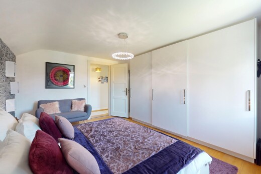 zimmer / schlafzimmer mit inside property, vaulted ceiling, dachschräge, wood finish floor, und holzfußboden