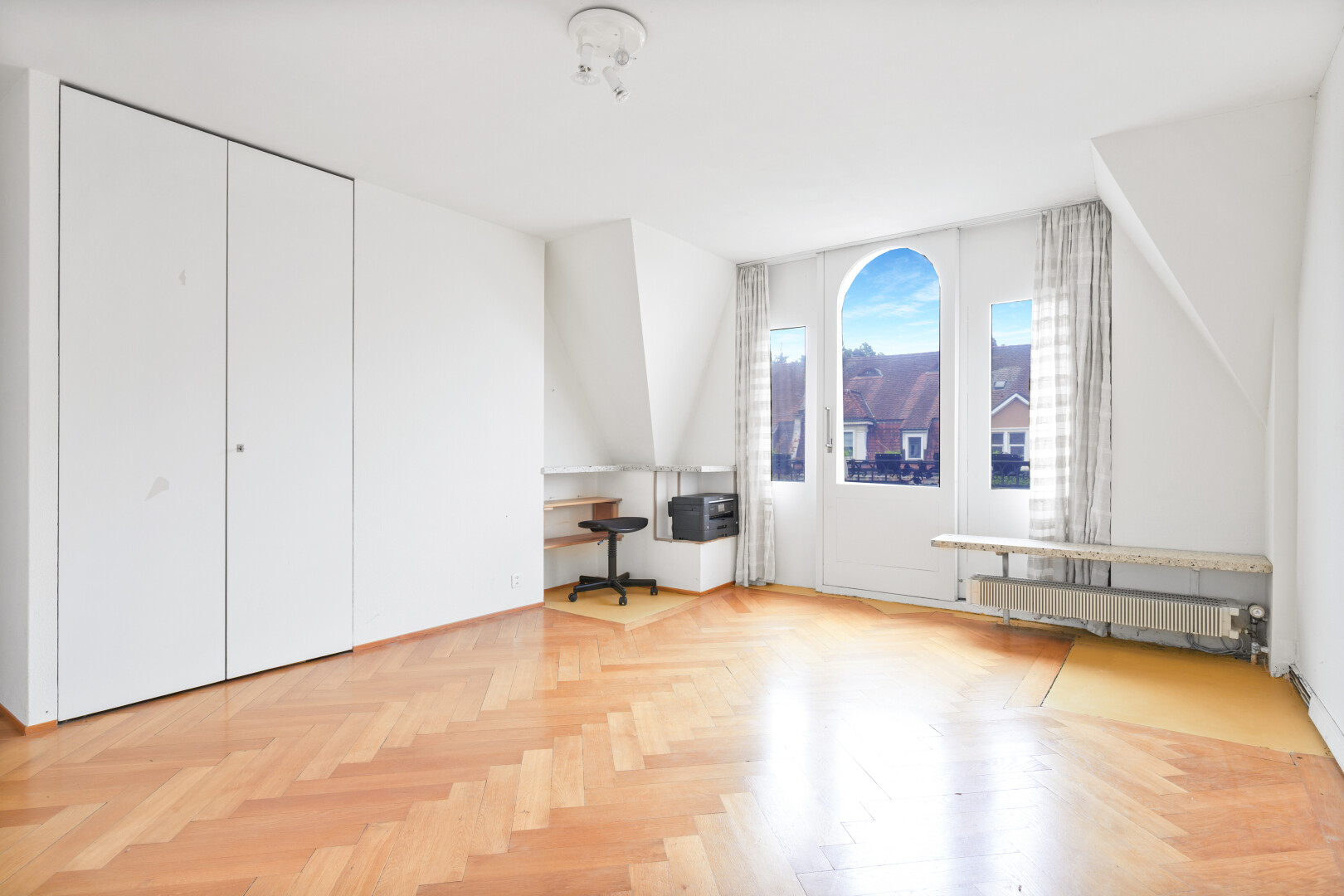 unfurnished room featuring radiator and a desk