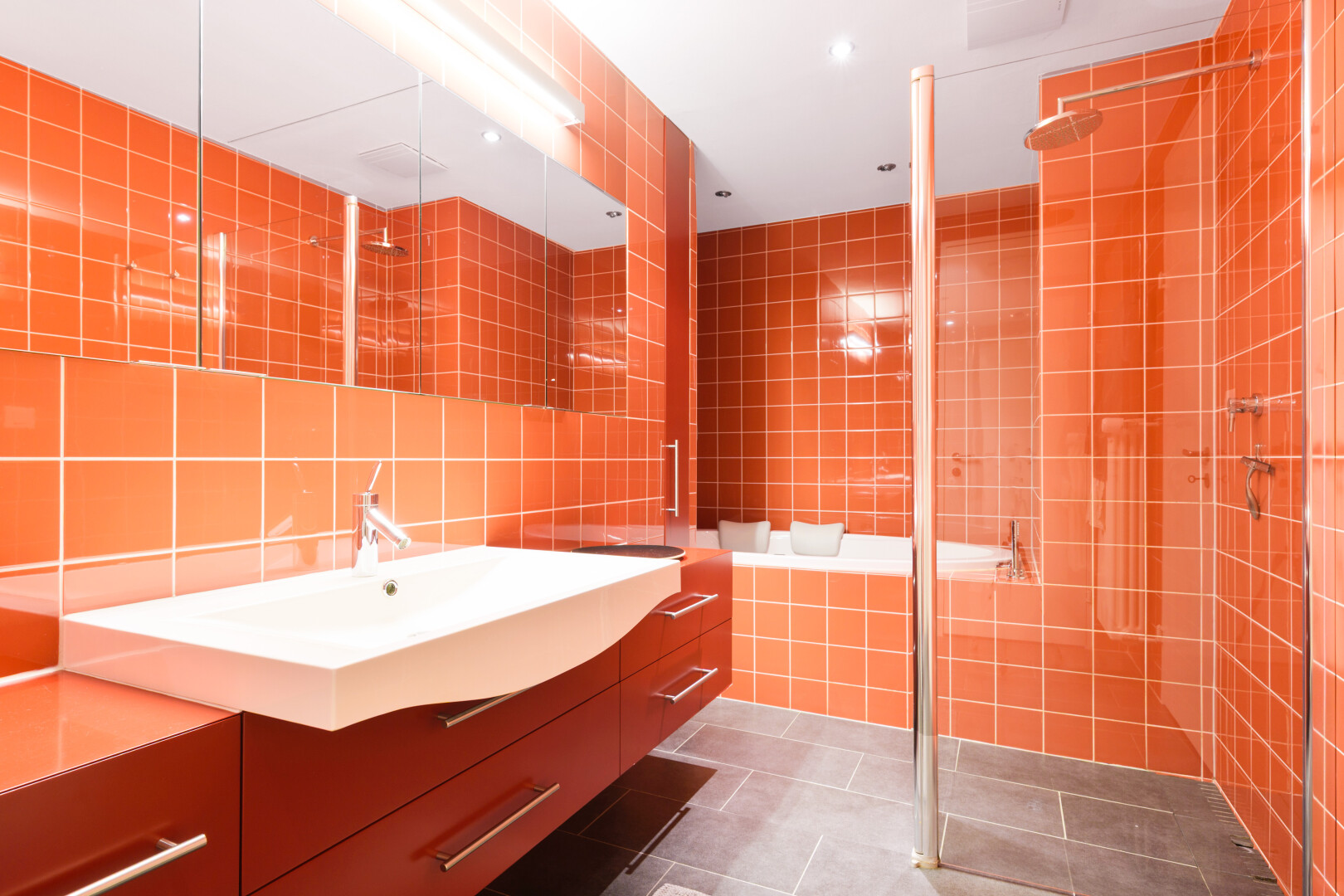 bathroom featuring tile walls, dark tile patterned floors, vanity, a stall shower, and decorative backsplash