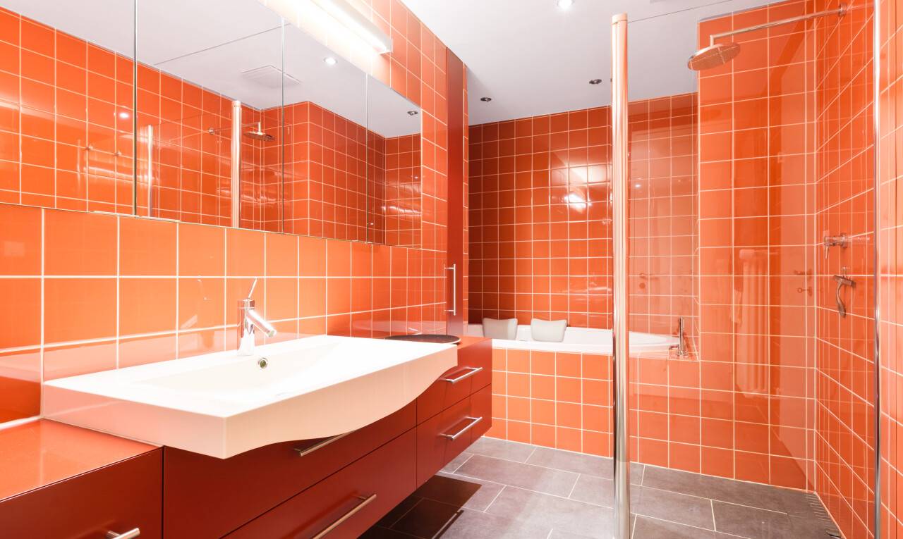 bathroom featuring tile walls, dark tile patterned floors, vanity, a stall shower, and decorative backsplash