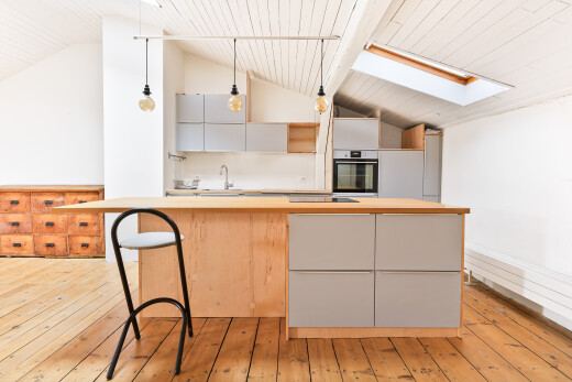 kitchen featuring decorative light fixtures, lofted ceiling, light wood-style flooring, light countertops, and oven