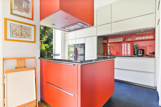 kitchen with modern cabinets, red cabinetry, and white cabinets