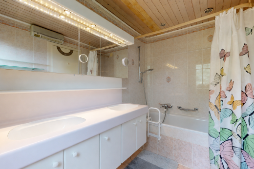 bathroom featuring double vanity, light tile patterned flooring, tile walls, and tiled shower / bath combo