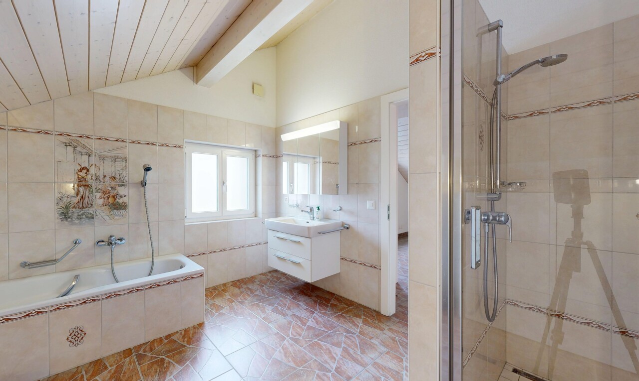 bathroom featuring tile walls, a tile shower, vanity, and tiled tub