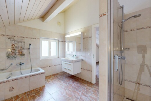 bathroom featuring tile walls, a tile shower, vanity, and tiled tub