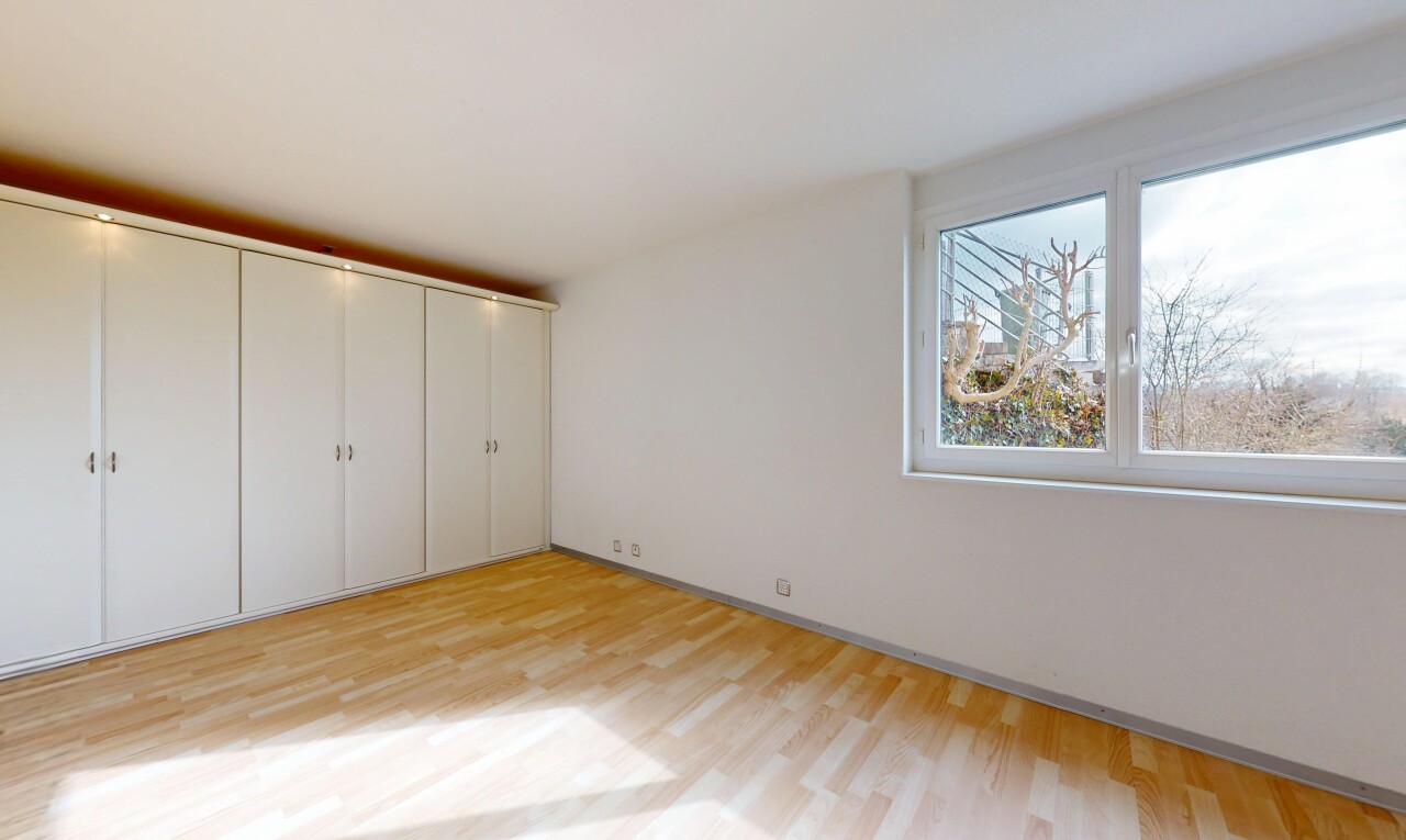 leerer raum mit holzfußboden, natürliches licht, und gipskartonwand