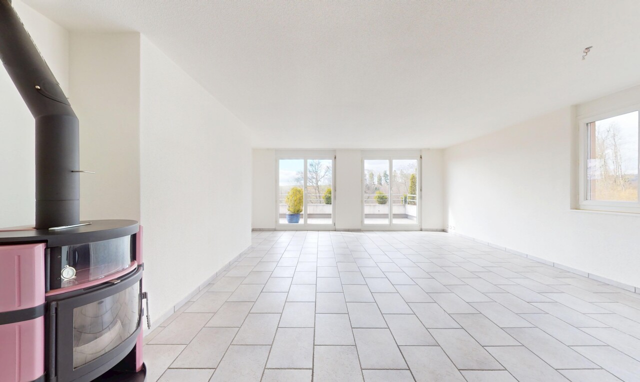 leerer raum mit holzofen, fliesenboden, natürliches licht, und gipskartonwand