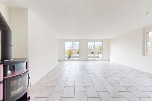 leerer raum mit holzofen, fliesenboden, natürliches licht, und gipskartonwand