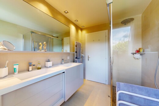 salle de bains avec douche, salle de bain complète, miroir, double vasque, et chauffe-serviettes
