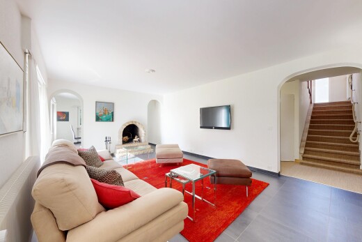 wohnzimmer mit gewölbte gehwege, inside property, fernseher, treppen, und drywall