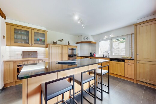 cuisine avec bar de cuisine, dosseret, backsplash, îlot de cuisine, et armoires avec moulures