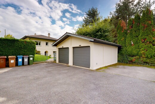 façade avec structure extérieure, day time, garage détaché, property visible, et bardage en stuc