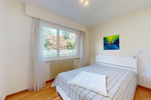 chambre avec natural light, lumière naturelle, radiateur, wood finish floor, et sol en finition bois