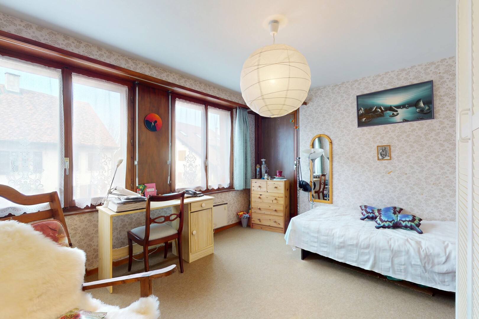 chambre avec lumière naturelle, mur en papier peint, et moquette