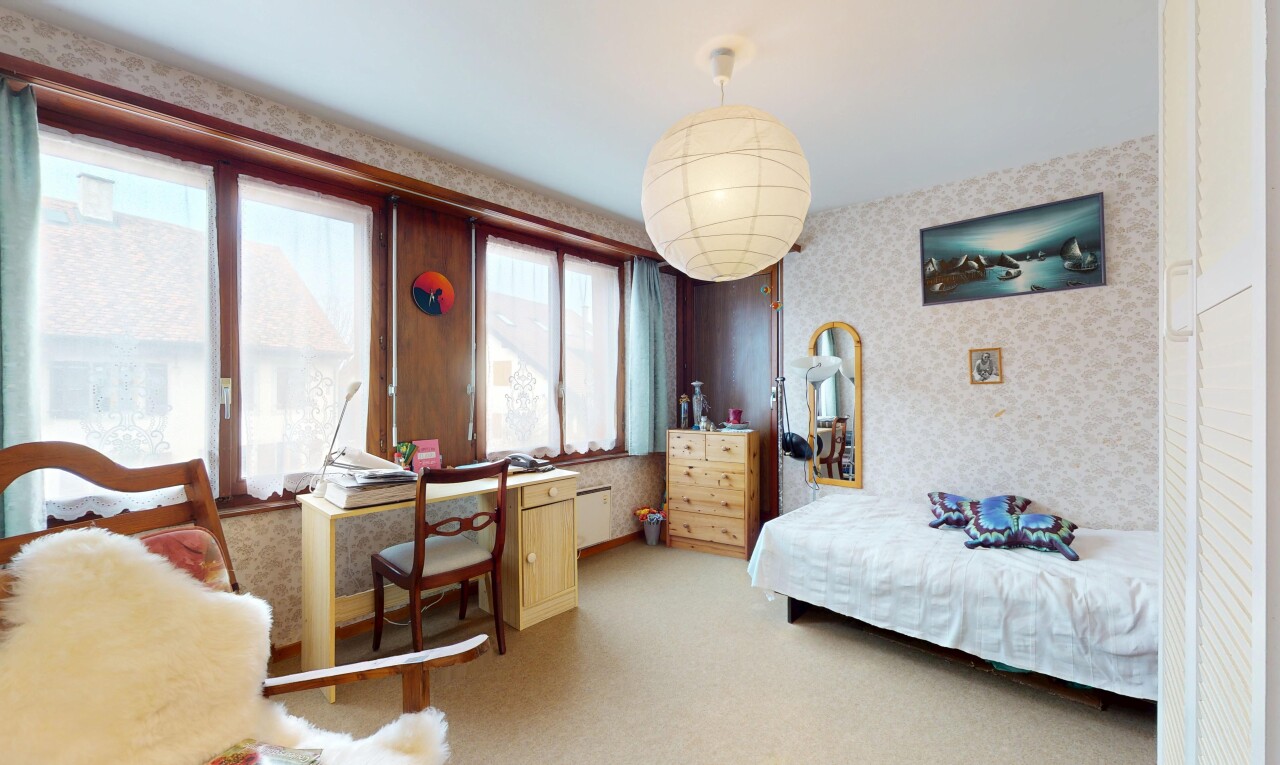 chambre avec lumière naturelle, mur en papier peint, et moquette