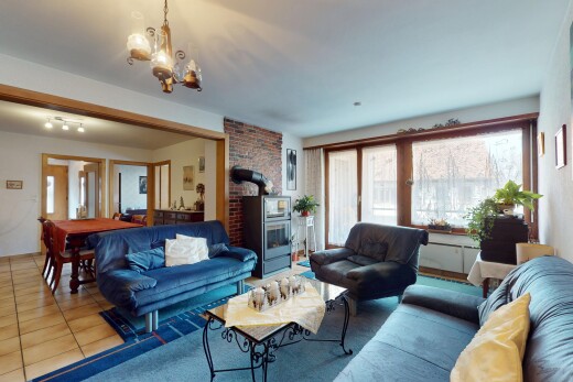 salon / salle à manger avec cloison sèche, lumière naturelle, poêle à bois, sol en carrelage, et lustre remarquable