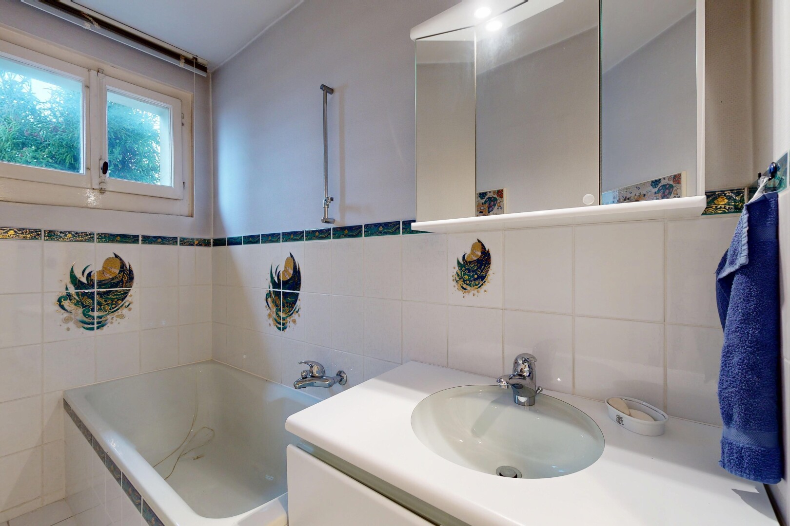 salle de bains avec salle de bain complète, lavabo (ou coiffeuse selon le contexte), bain, miroir, et évier