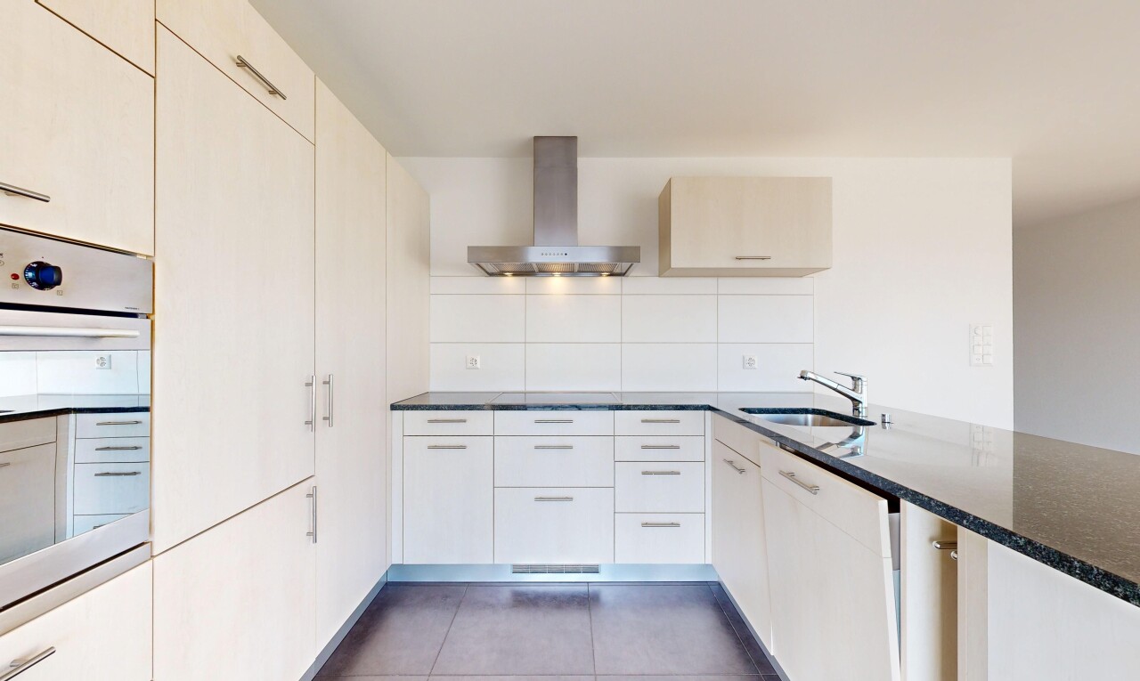 cuisine avec hotte, plans de travail en pierre, four, sol en carrelage, et tile floor