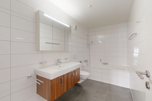 bathroom with vanity, dark tile patterned flooring, tile walls, and tiled shower / bath combo