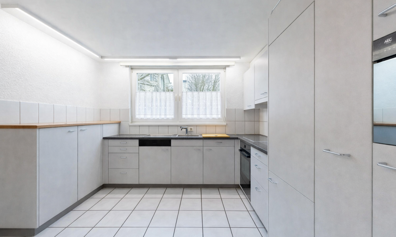 kitchen featuring dark countertops, dishwasher, oven, white cabinetry, and light tile patterned floors