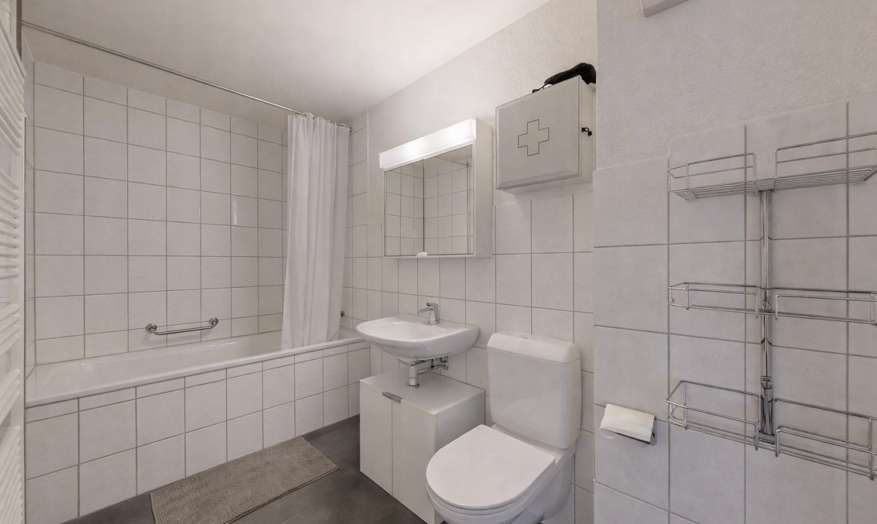 bathroom featuring tiled shower / bath, dark tile patterned flooring, and tile walls