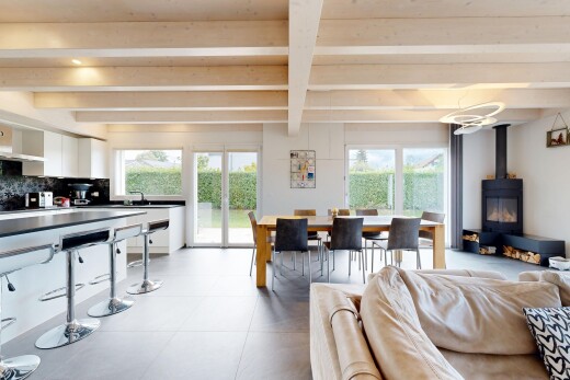 salon / salle à manger avec plafond à poutres, beamed ceiling, poêle à bois, inside property, et lumière naturelle