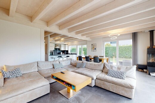 salon avec beamed ceiling, plafond à poutres, poêle à bois, natural light, et lumière naturelle