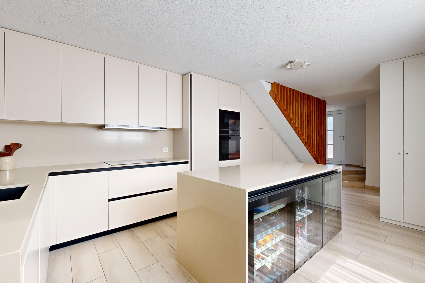 cuisine avec waterfall edge countertops, armoires à panneau plat, flat panel cabinets, light floor, et light countertops