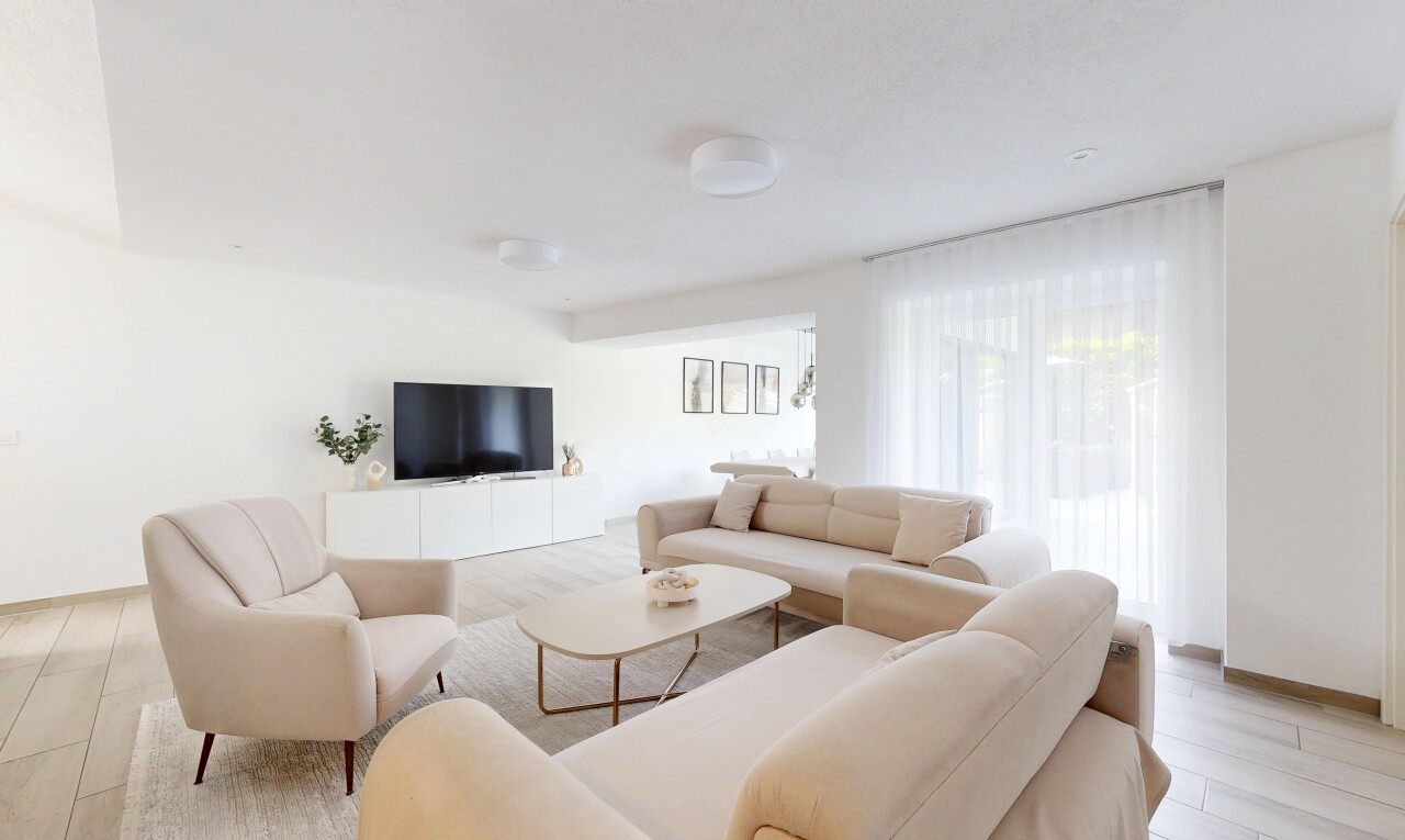 salon avec inside property, cloison sèche, drywall, télévision, et lumière naturelle