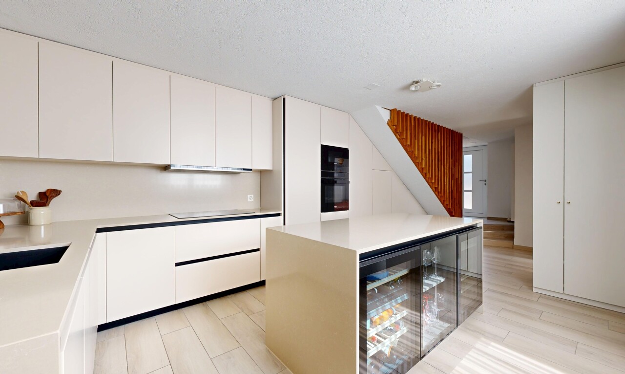 cuisine avec waterfall edge countertops, armoires à panneau plat, flat panel cabinets, light floor, et light countertops