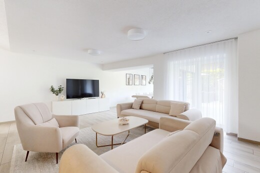 salon avec inside property, cloison sèche, drywall, télévision, et lumière naturelle