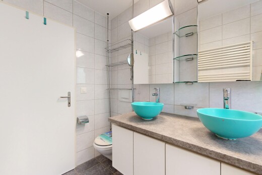 salle de bains avec inside property, dark floor, radiateur, évier, et double vasque