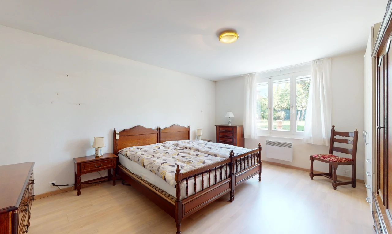 chambre avec lumière naturelle, plancher de bois, et radiateur