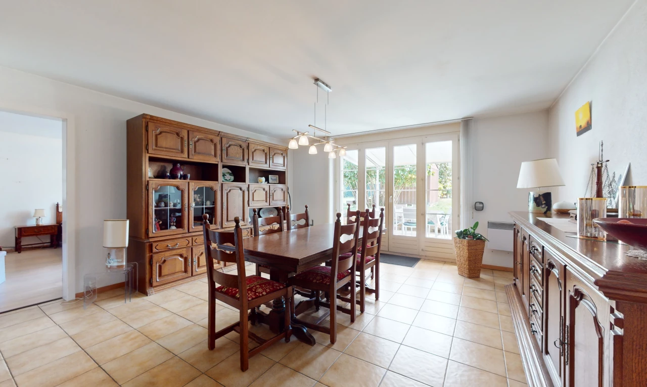 salle à manger avec lumière naturelle, carrelage, et lustre