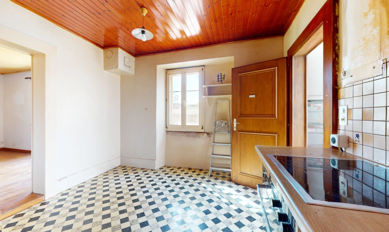 cuisine avec plafond de bois, lumière naturelle, carrelage, et cuisinière