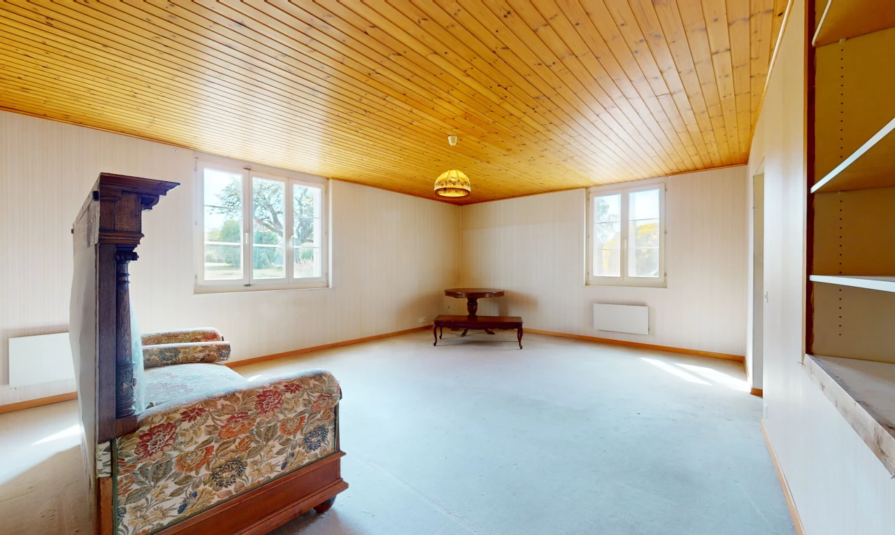 chambre avec plafond de bois, lumière naturelle, et radiateur