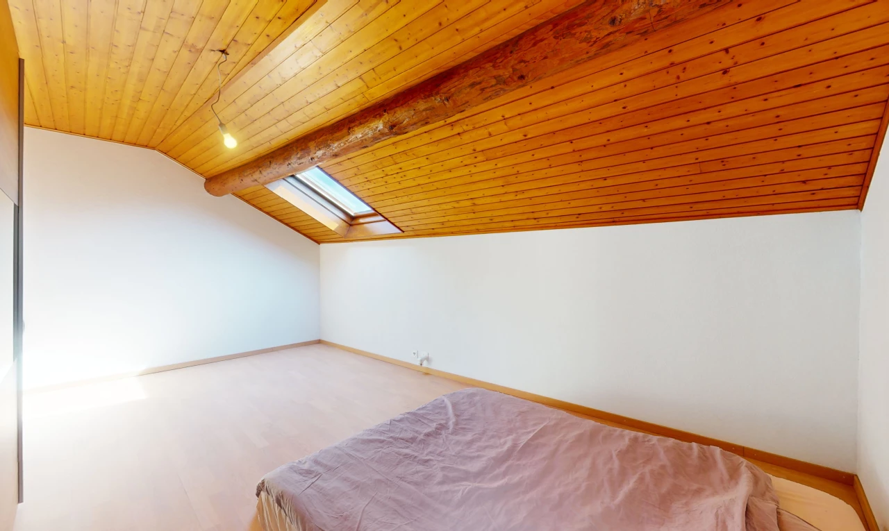 chambre avec plafond voûté, poutres apparentes, plancher de bois, plafond de bois, et lucarne