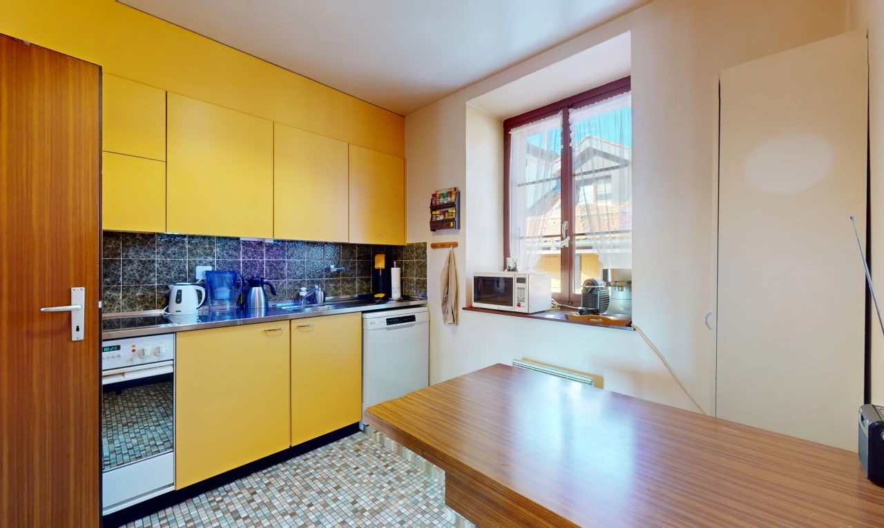 cuisine avec four, lave-vaisselle, carrelage, micro-ondes, et plan de travail