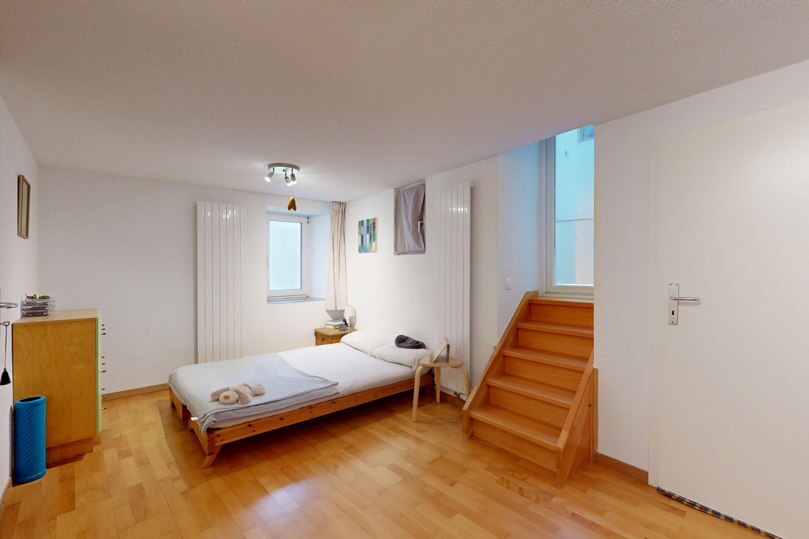 chambre avec wood finish stairs, drywall, cloison sèche, inside property, et wood finish floor
