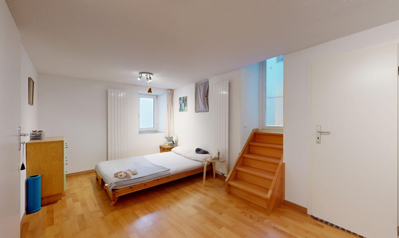 chambre avec wood finish stairs, drywall, cloison sèche, inside property, et wood finish floor