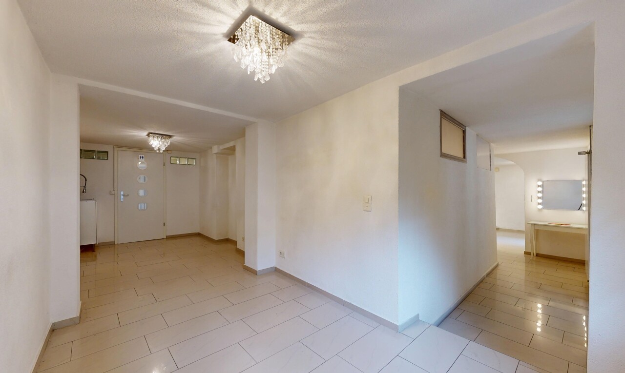 pièce vide avec drywall, cloison sèche, light floor, inside property, et passages en arc