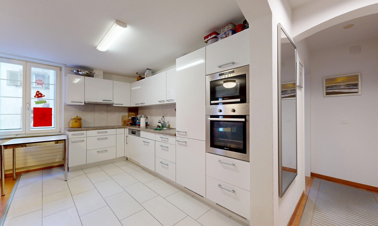 cuisine avec light floor, white cabinets, armoires blanches, passages en arc, et four double