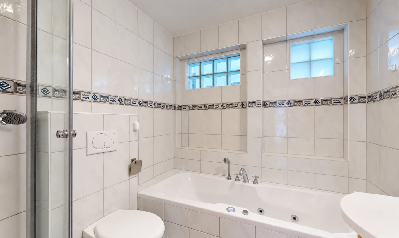 salle de bains avec salle de bain complète, bain, mur en carrelage, tile wall, et inside property