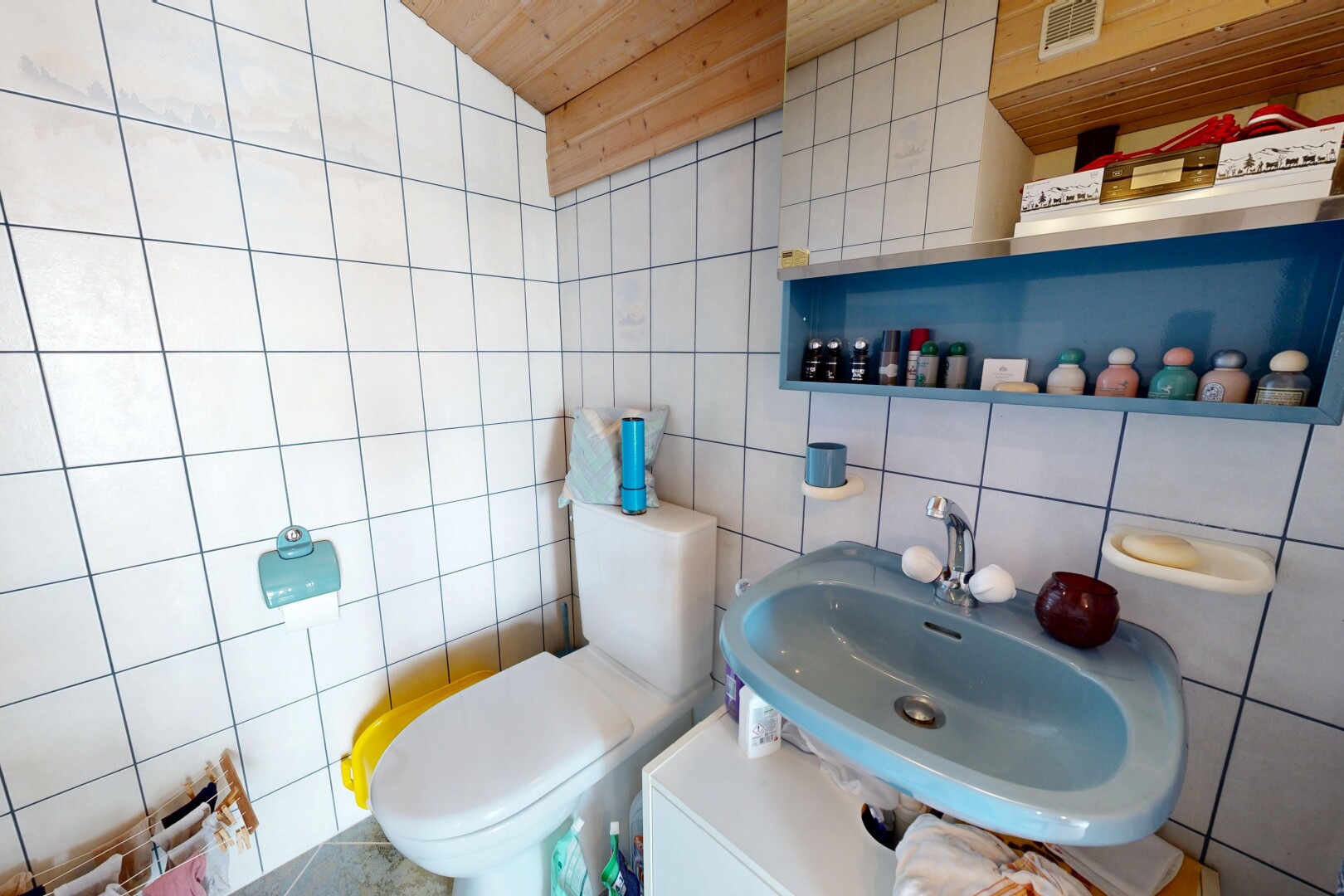 salle de bains avec mur en carrelage, tile wall, toilette, évier, et inside property