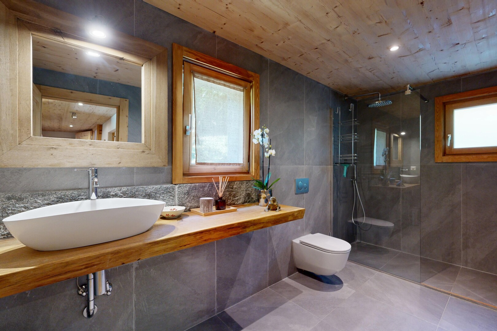 salle de bains avec mur en carrelage, tile wall, miroir, lavabo (ou coiffeuse selon le contexte), et évier
