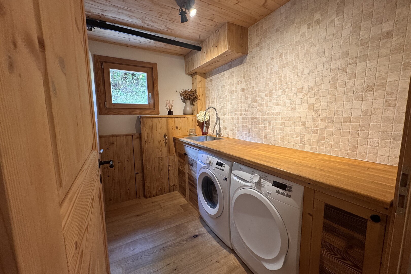 buanderie avec buanderie, inside property, light floor, évier, et lave-linge et sèche-linge séparés
