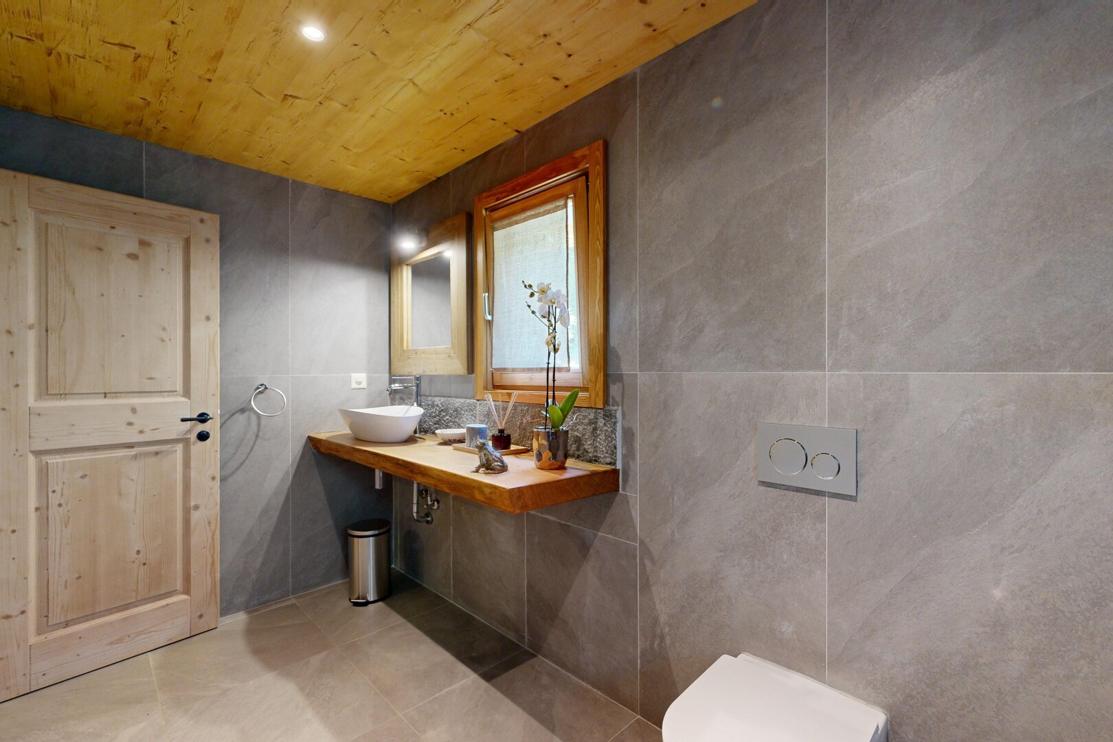 salle de bains avec mur en carrelage, tile wall, lavabo (ou coiffeuse selon le contexte), miroir, et inside property