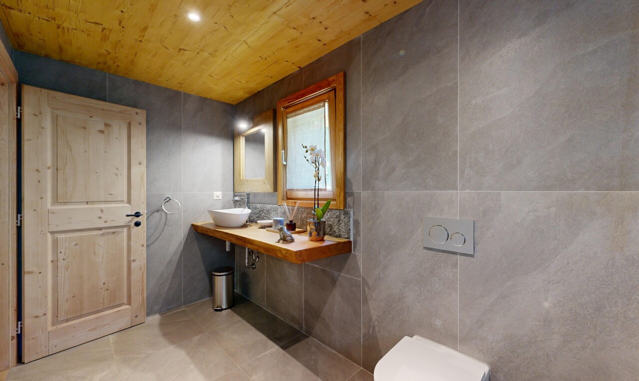 salle de bains avec mur en carrelage, tile wall, lavabo (ou coiffeuse selon le contexte), miroir, et inside property