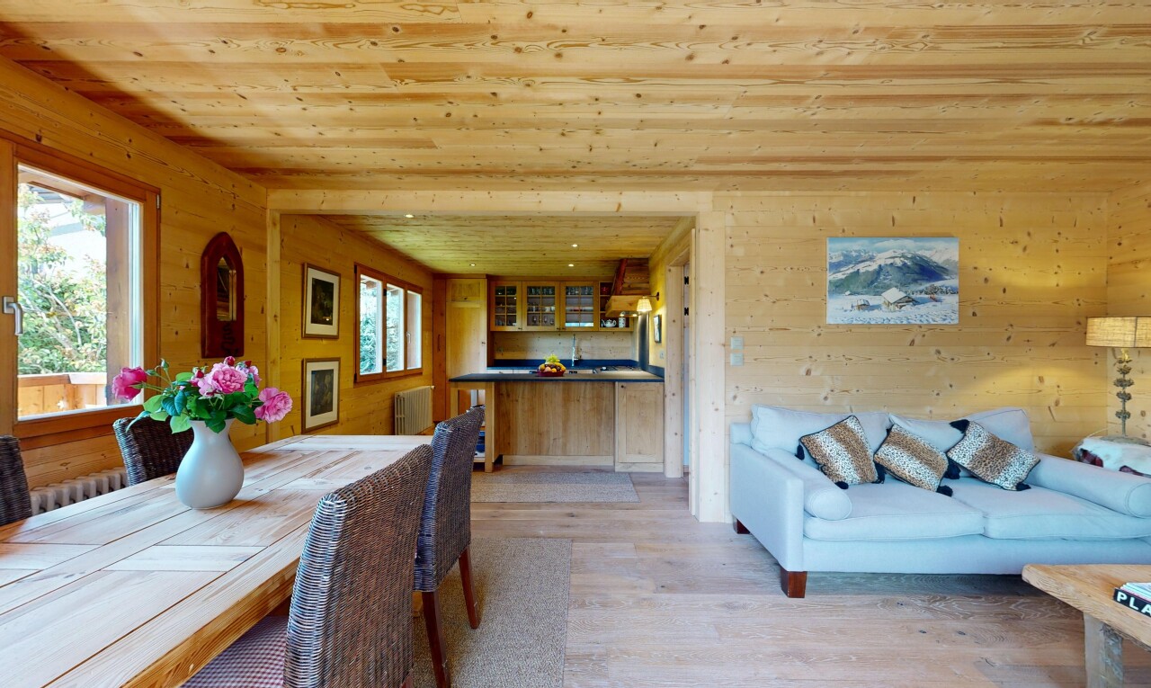 salon / salle à manger avec mur en bois, wood wall, light floor, inside property, et sol en finition bois
